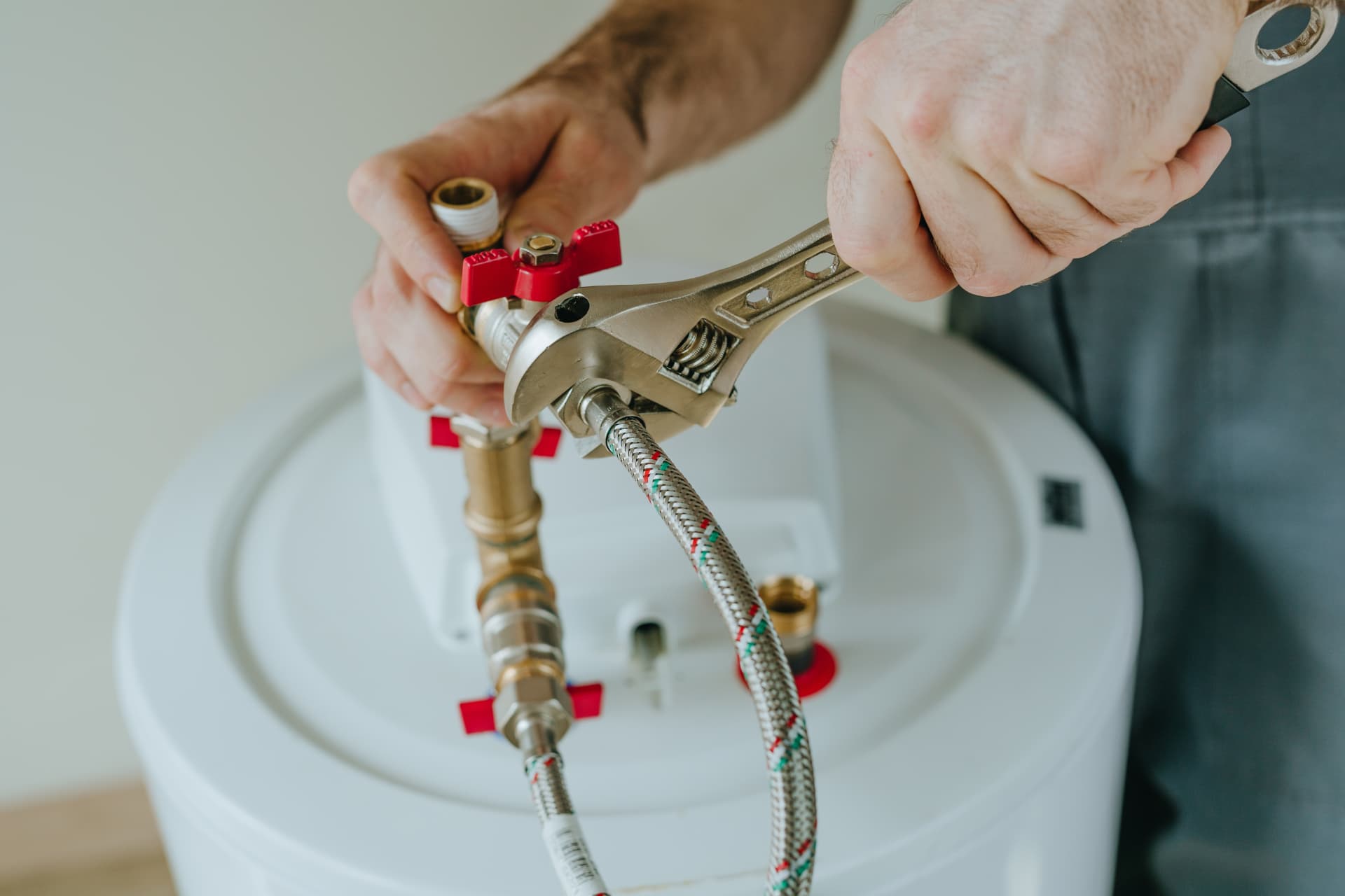 Engineer using a spanner on heating pipe connections